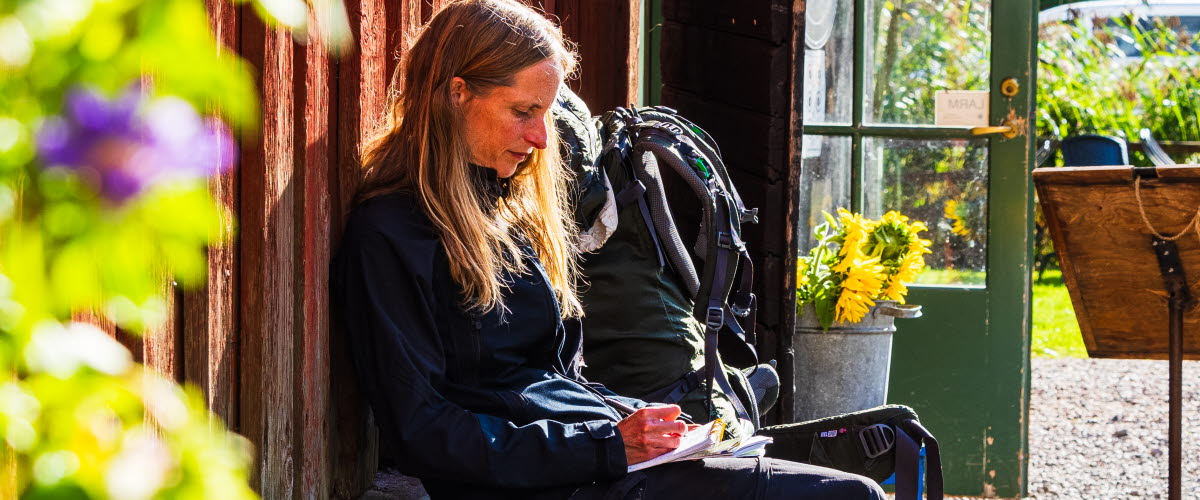 Kvinna sitter på bänk utanför café