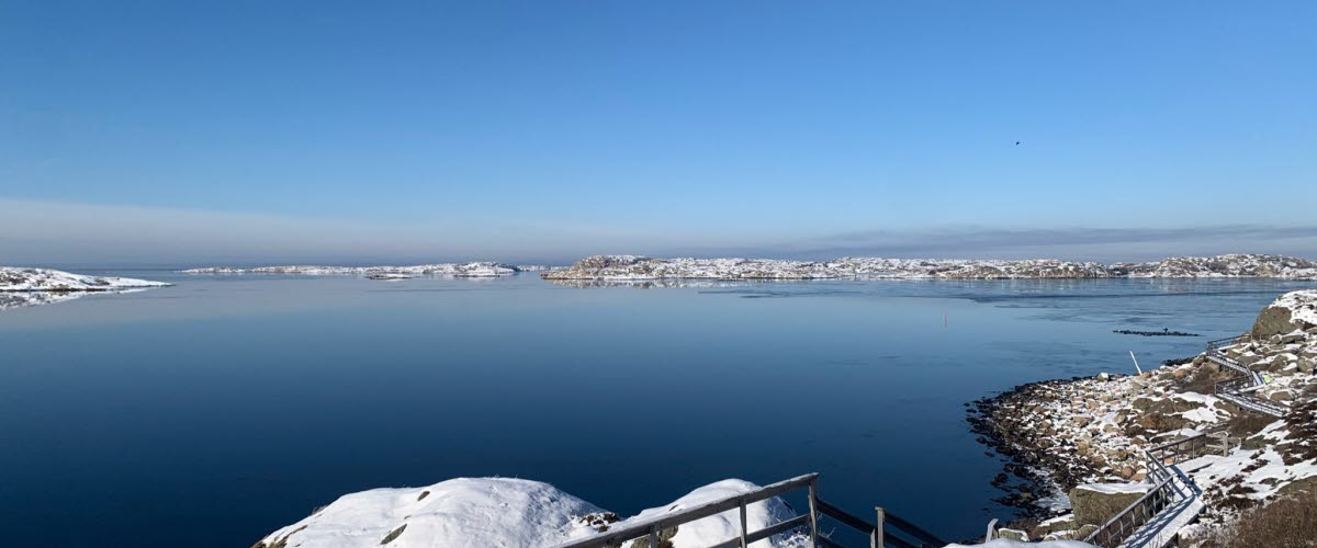 Vintrig vy med snö över havet och Strandpromenaden i Grundsund.